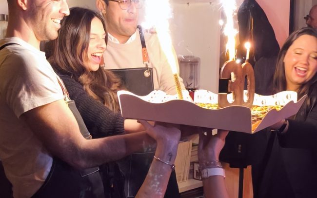 Momento de tarta y brindis durante un cumpleaños con taller de cocina