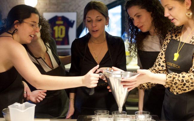 Grupo preparando tiramisú y otros postres en taller de repostería en Barcelona