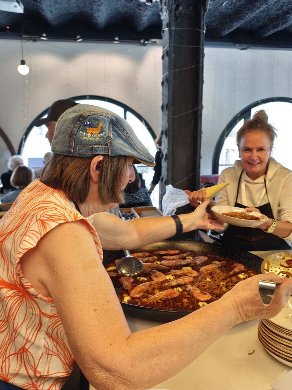 Guests serving paella during a Spanish cooking class in Barcelona